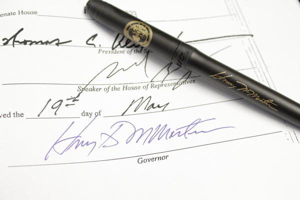 Governor’s Signature and Ceremonial Pen Given to Acting Director Melvin Warren